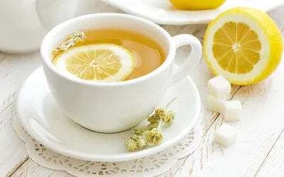 Самовар, чашка чая, лимон, сахар и конфеты под солнечными лучами. Чай с  лимоном это классическое сочетание. Чай на фоне цветов смотрится ярко и  аппетитно. фотография Stock | Adobe Stock
